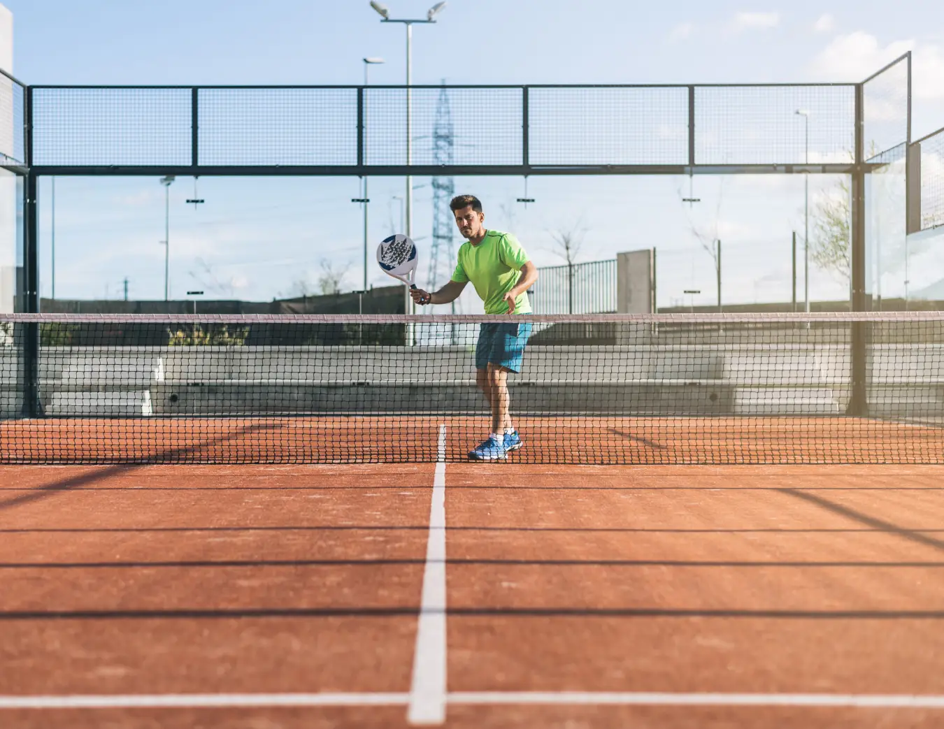 Een jongen op een padelbaan aan het sporten na werk
