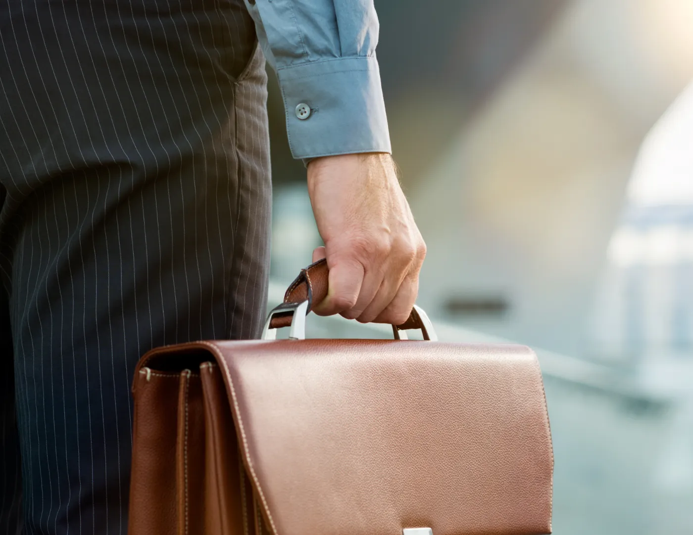 Werknemer in pak die een werktas in zijn hand heeft