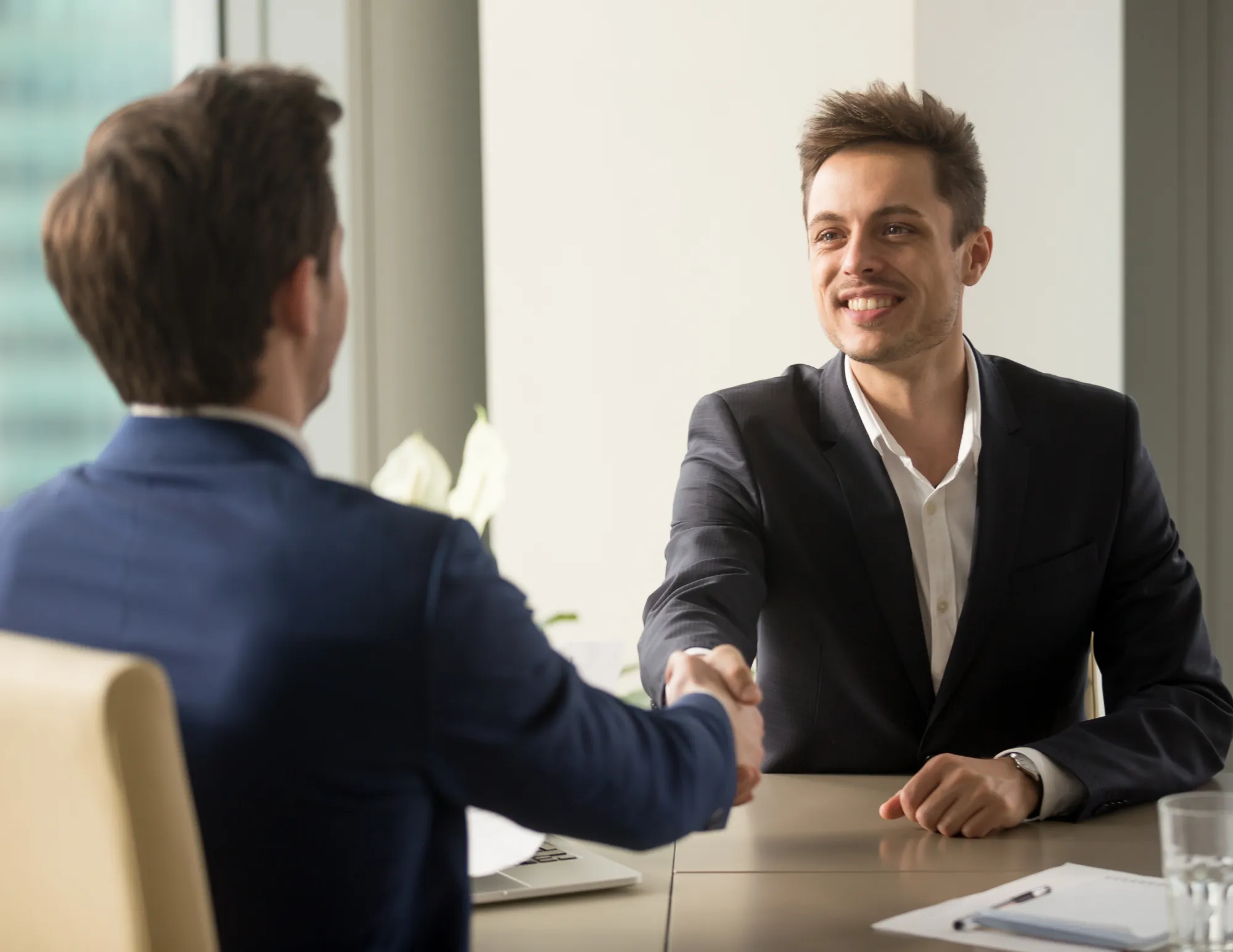 Man schudt hand andere man want hij is aangenomen