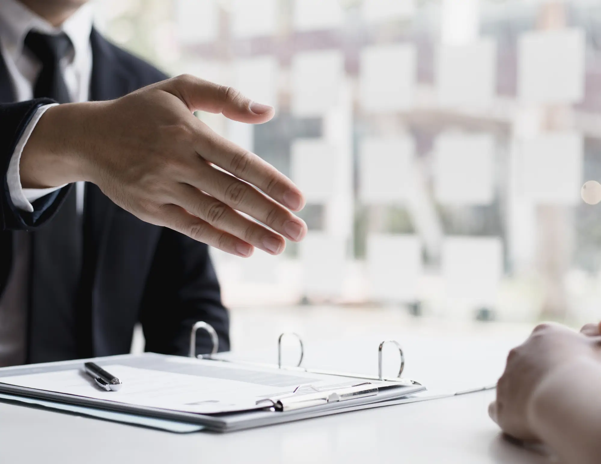 Man schudt hand bij sollicitatie met cv voor hem