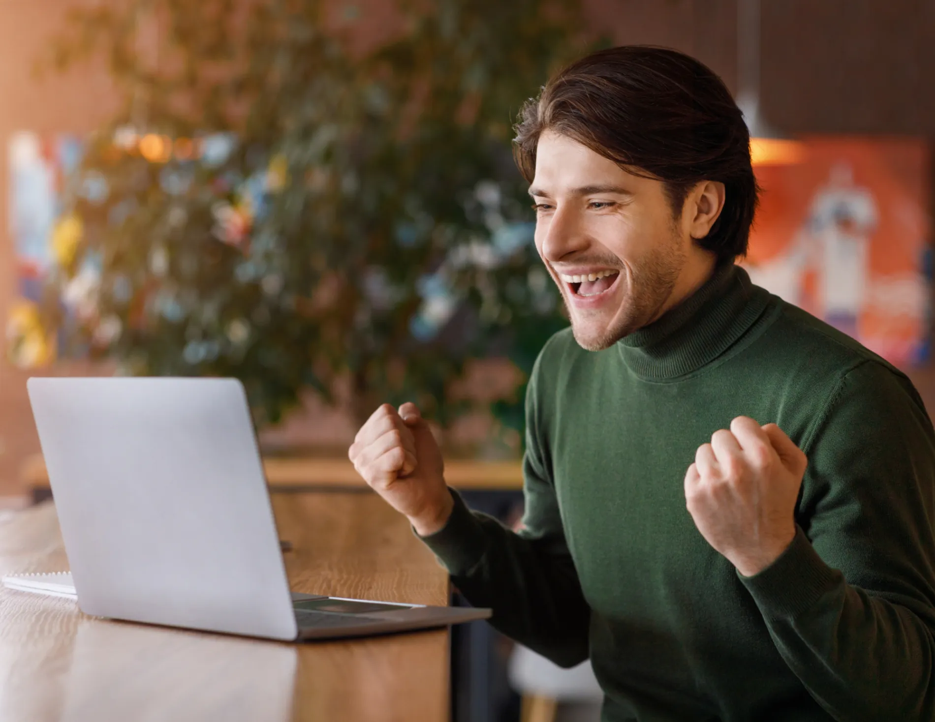 Man blij achter laptop nieuwe baan