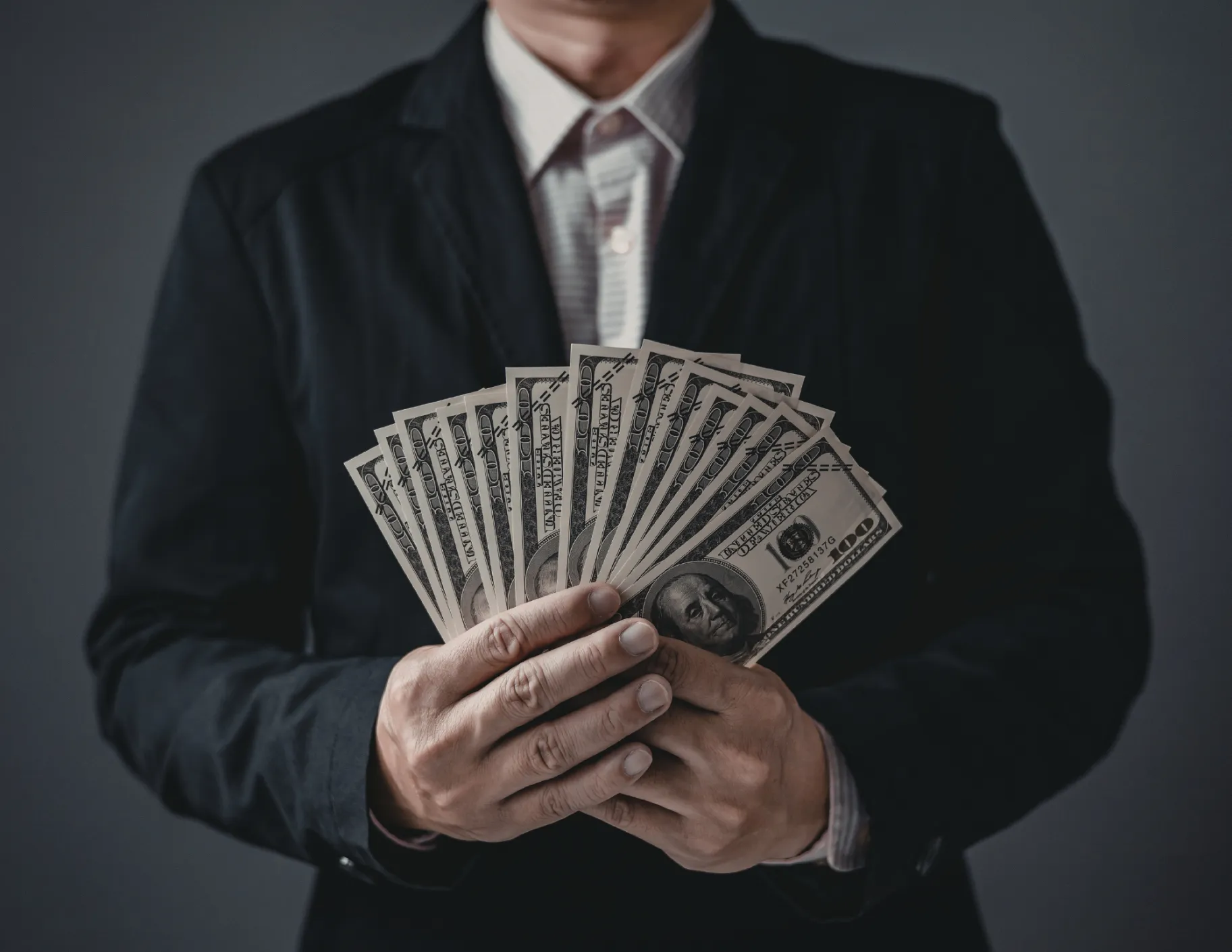Man in pak met veel briefgeld in zijn handen
