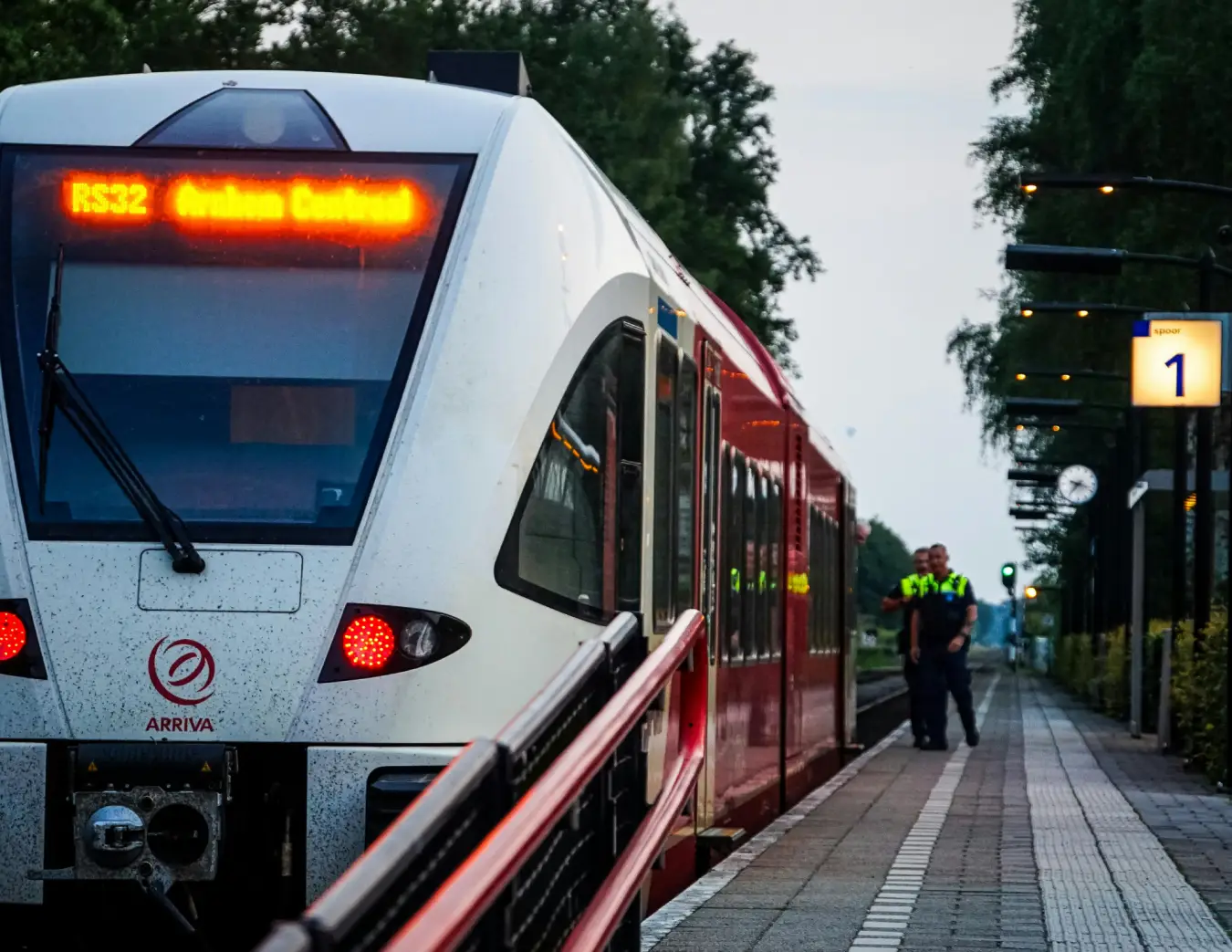 Trein stilstaand op een perron met politieagenten