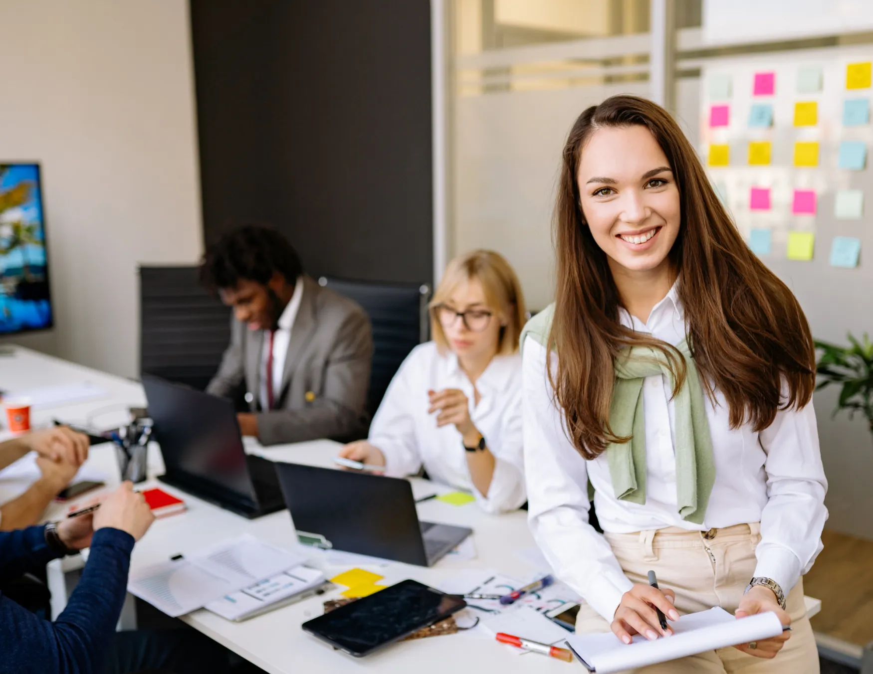 Vrouw aan het werk op papier met medewerkers achter zich