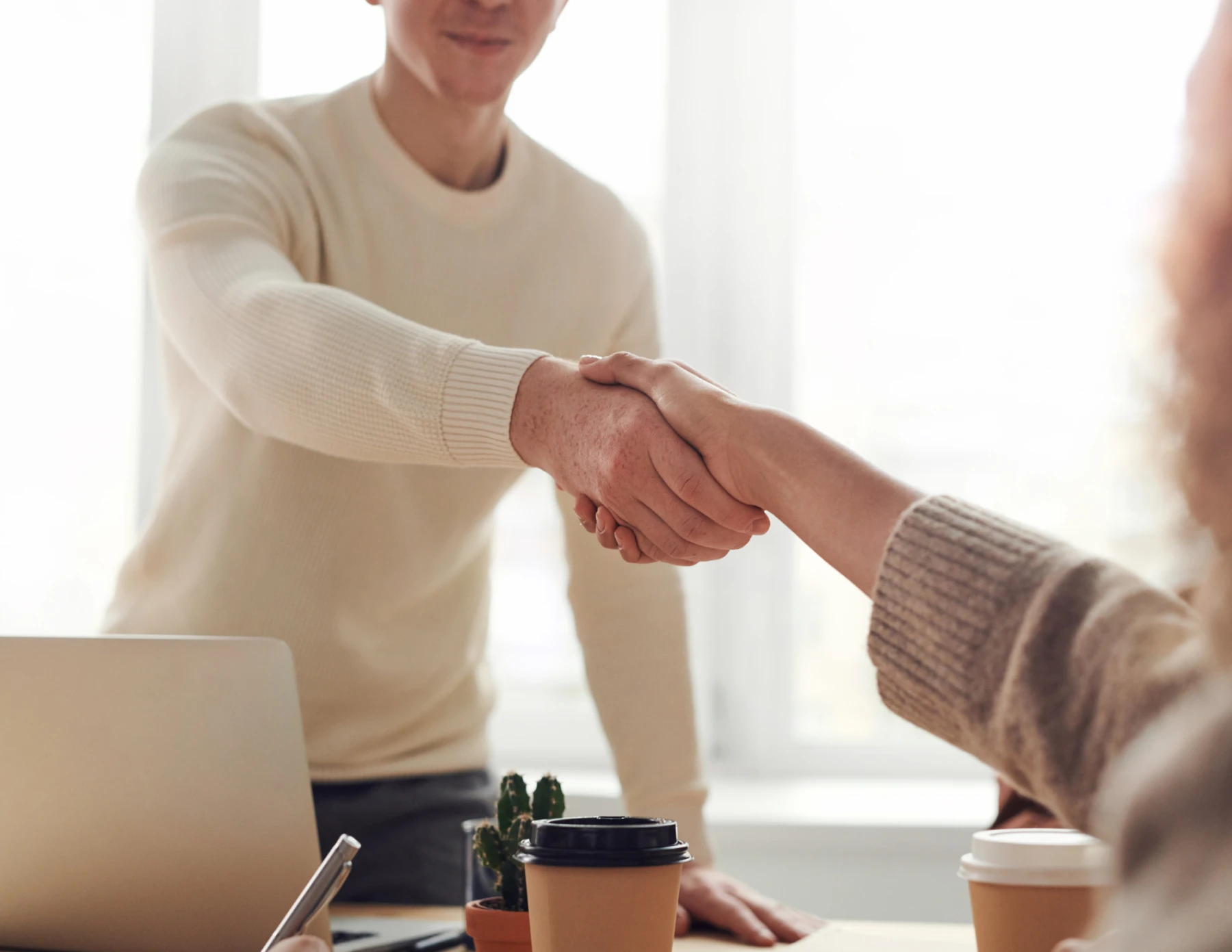 Man en vrouw schudden de hand tijdens een sollicitatiegesprek