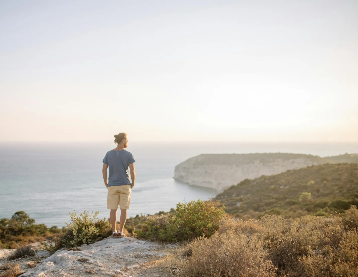 Man op reis met uitzicht over zee en bergen