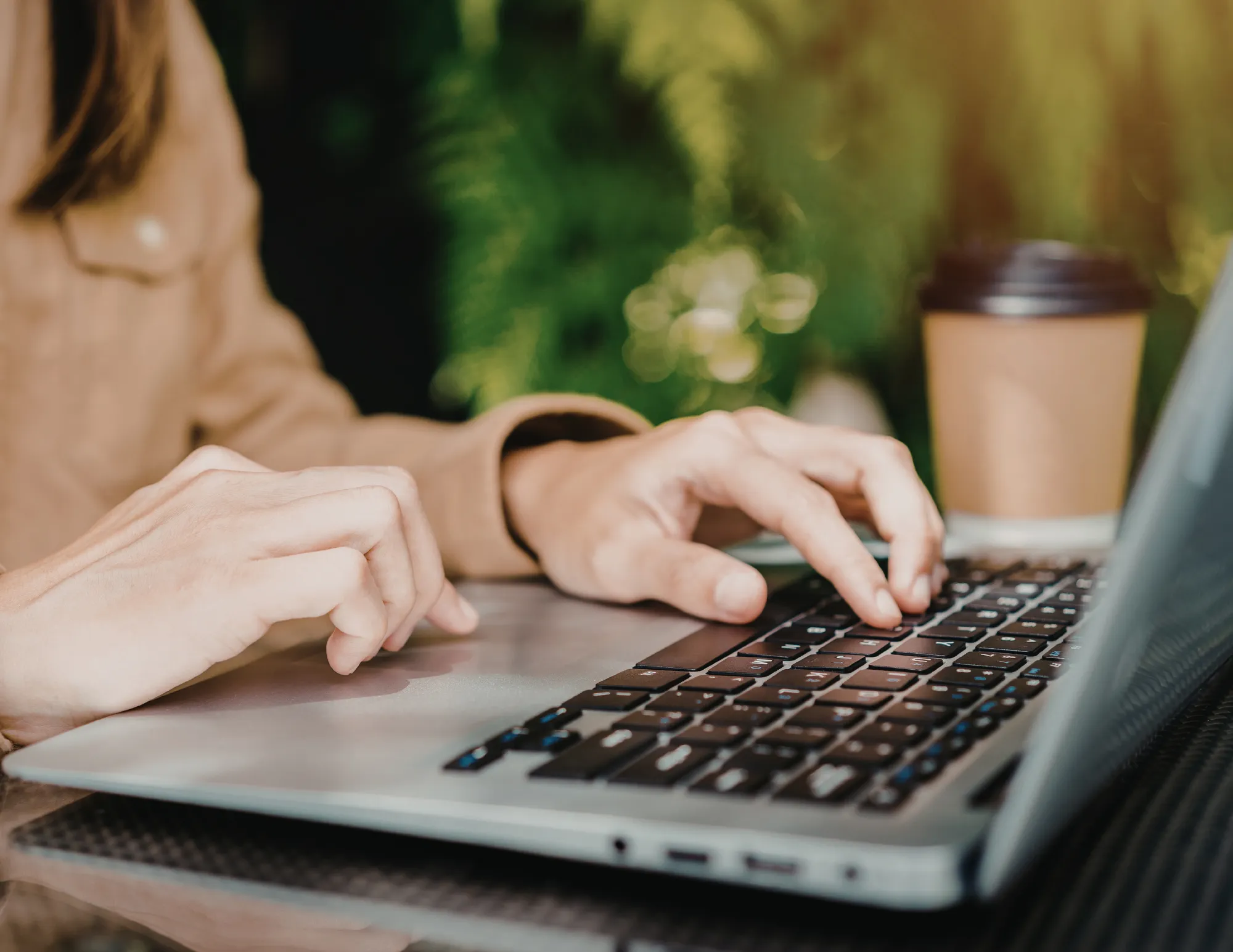 Vrouw achter laptop aan het typen / werken