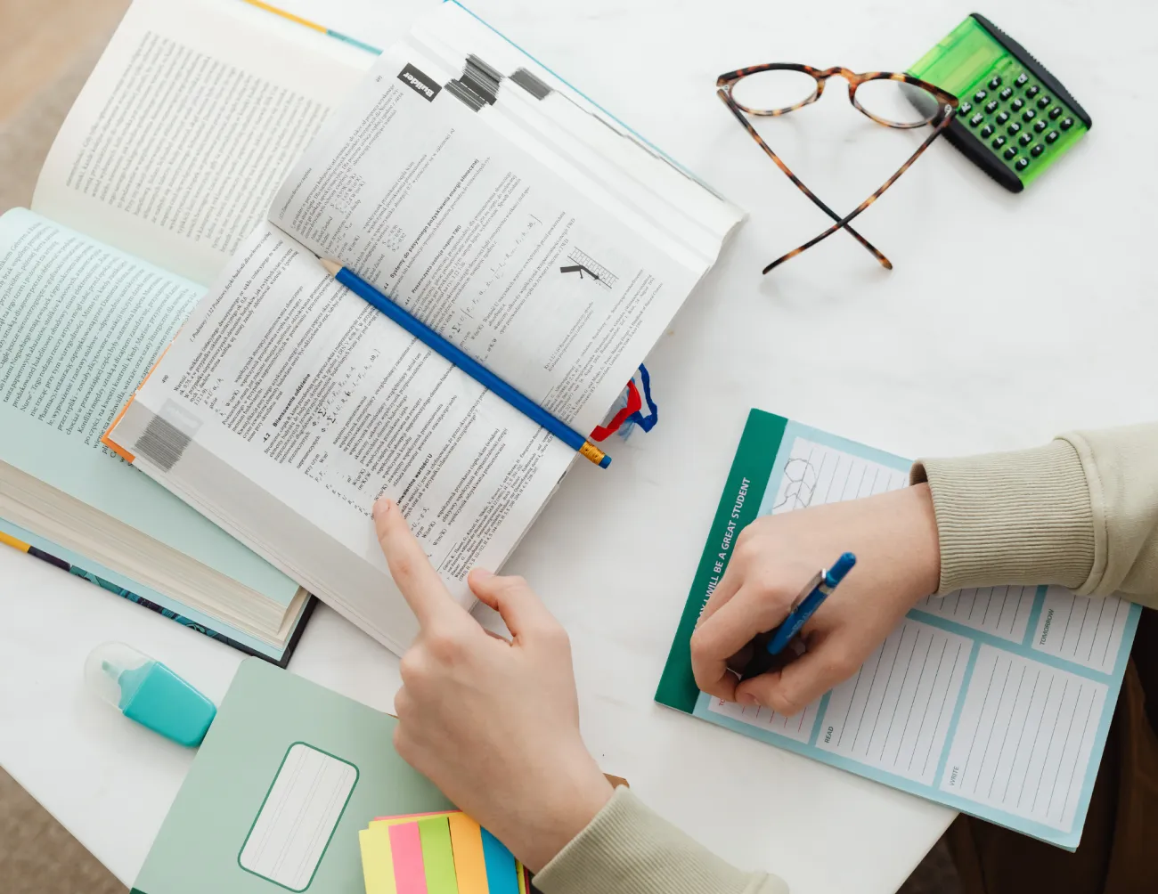 Persoon aan het studeren en schrijven met boeken en schriften
