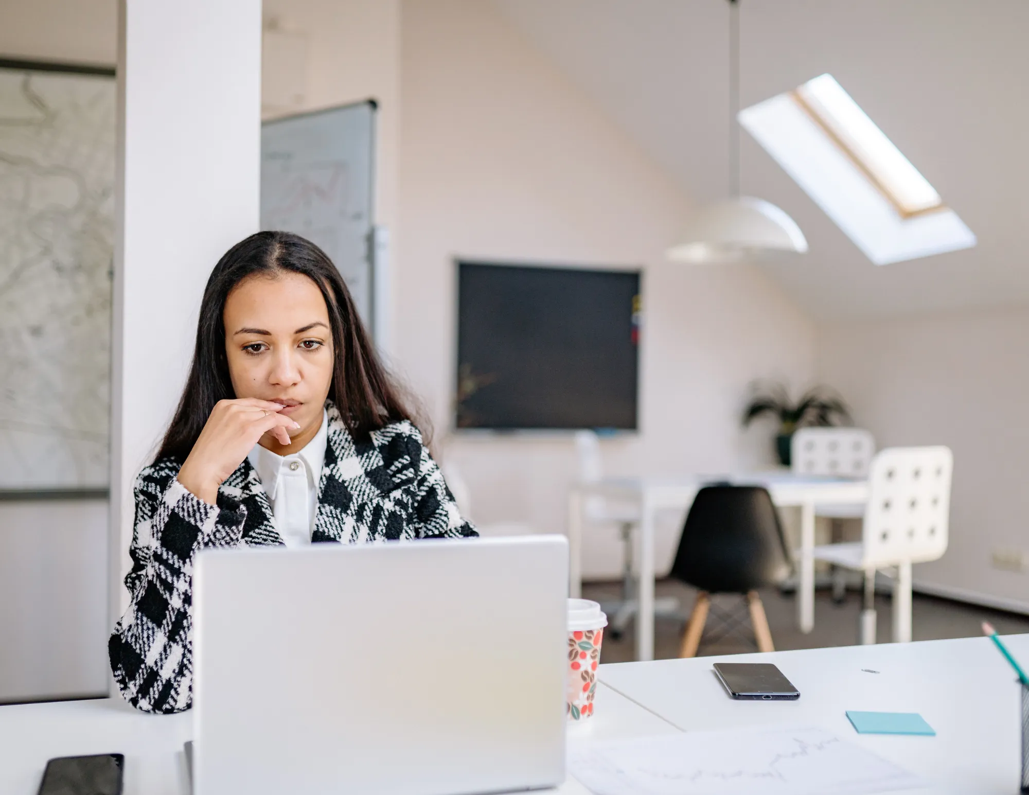 Moeilijk kijkende dame achter laptop die aan het werk is
