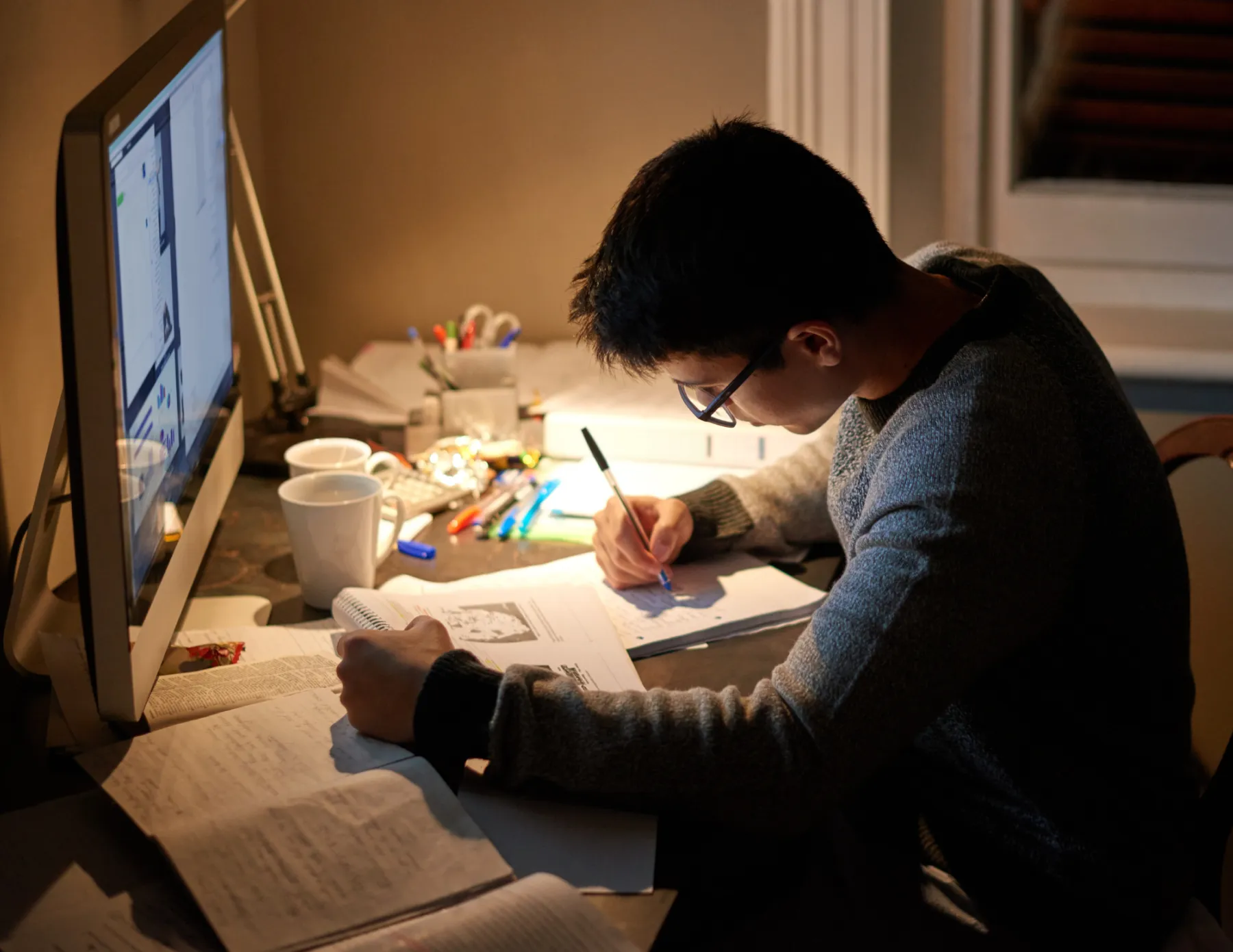 Student met papier en computer aan het studeren