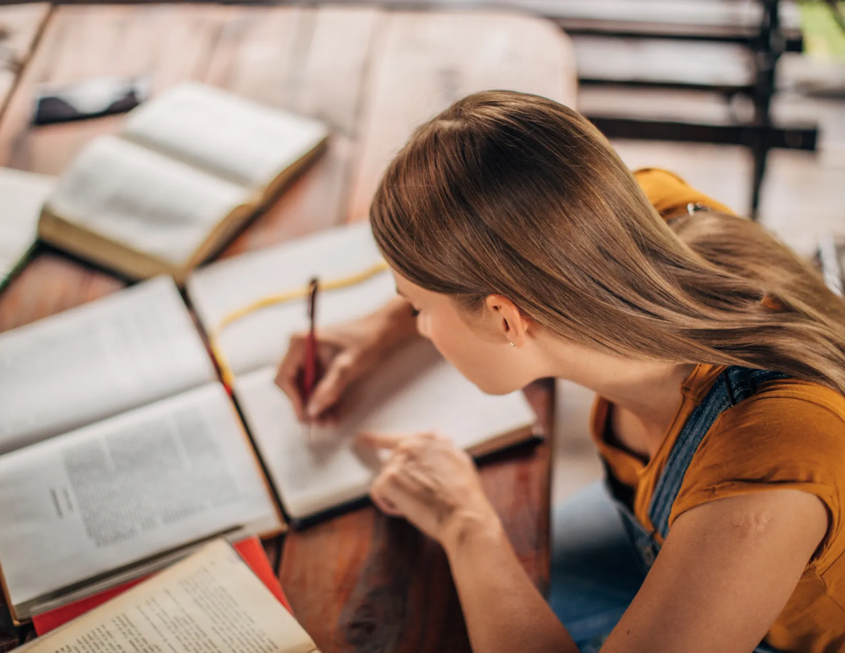Vrouw die aan het studeren is met schriften en een pen